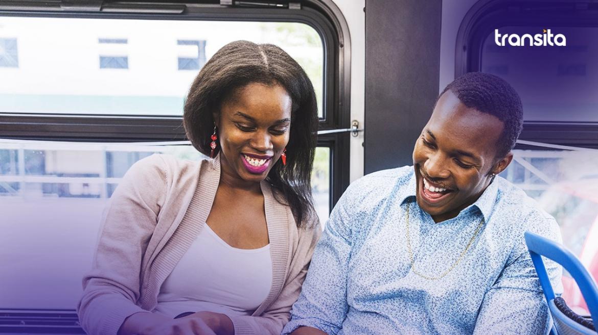 Man and woman smiling on a bus